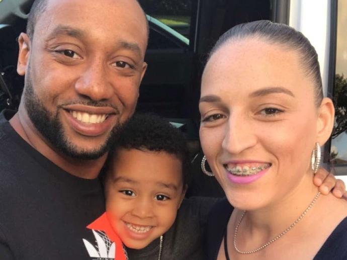 two parents and young child smiling
