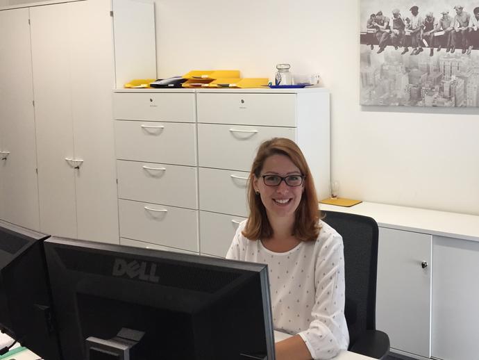 female employee smiling from behind desk