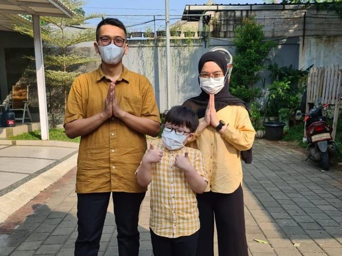 Family of three on Eid wearing masks