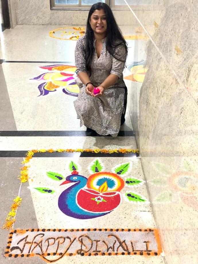 Keller employee smiling in front of Rangoli for Diwali