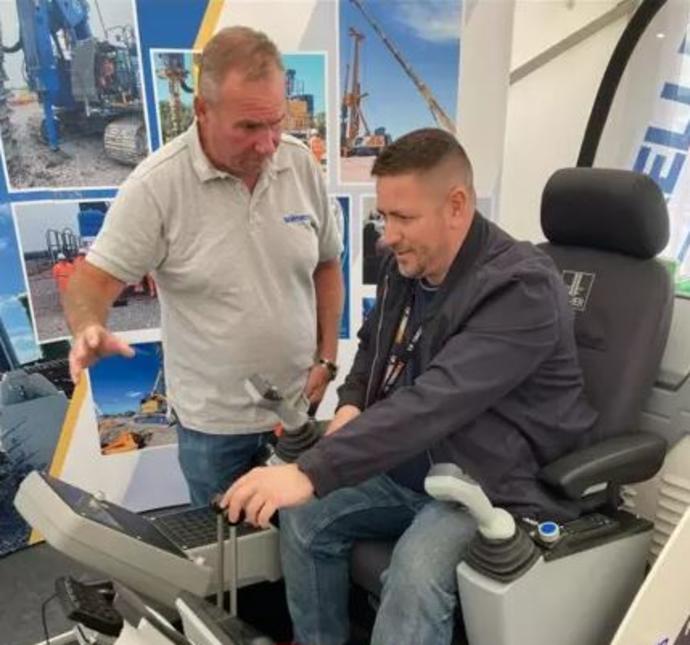 Aaron Armstrong (right) tries out a piling rig simulator