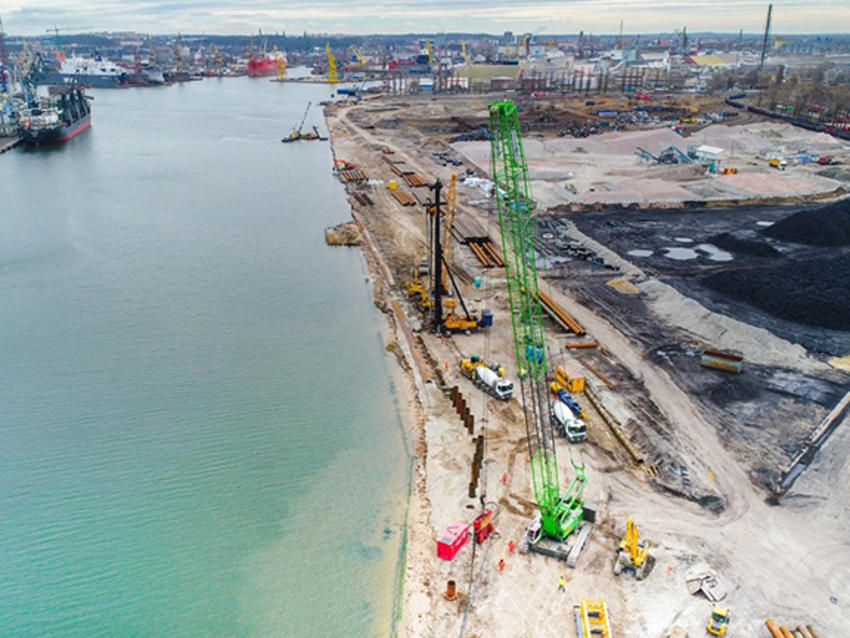 large green rig and other yellow ones on port construction site