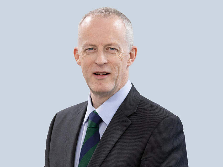 male employee wearing stripe tie and suit headshot