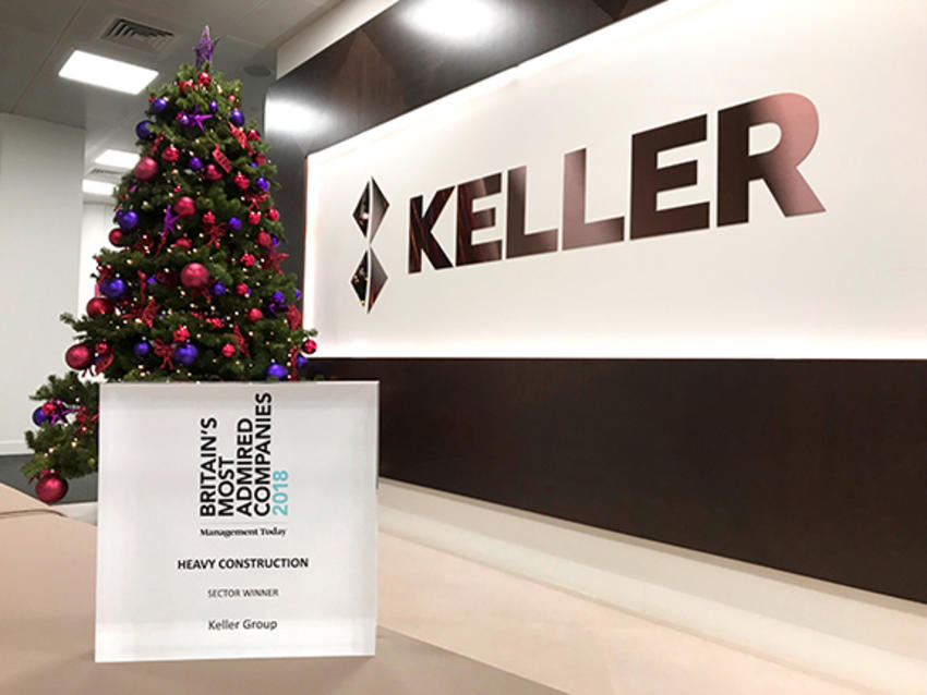 glass award in front of christmas tree and company logo