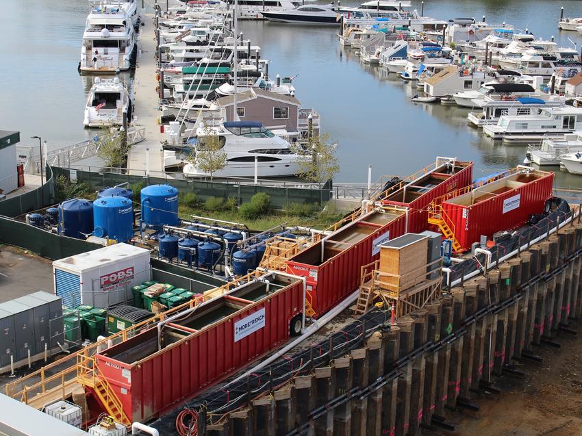 red tanks next to boats on riverside docks