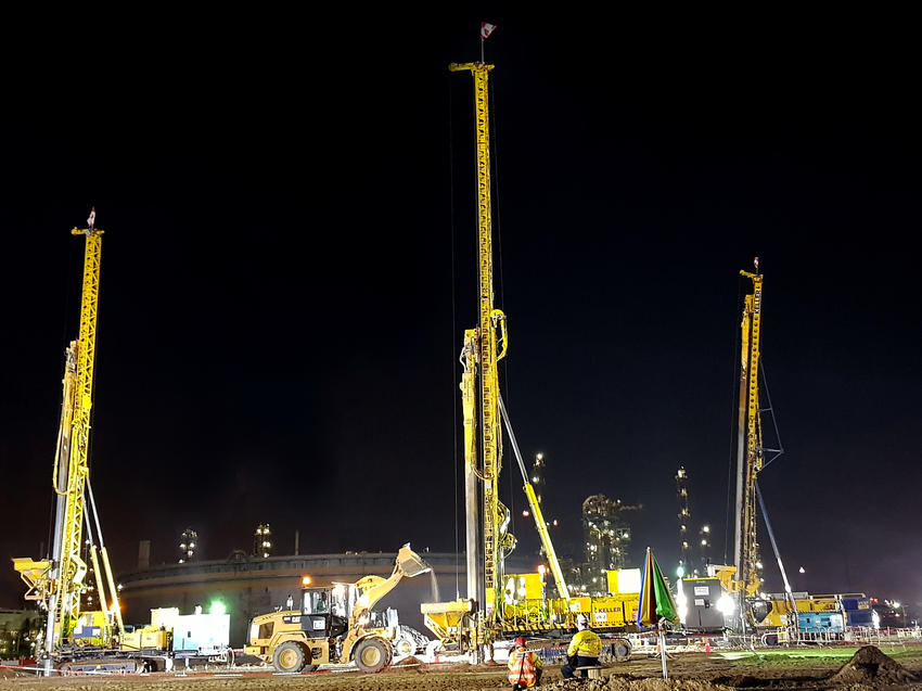 three yellow keller rigs working at night on construction site