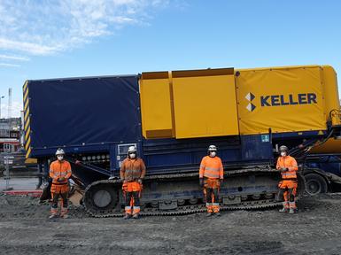 four keller employees in orange clothing in front of equipment