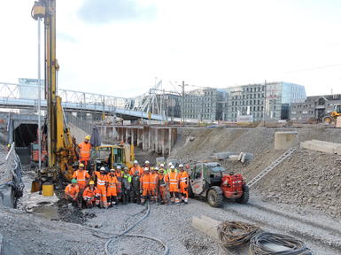team of workers in front of rig in excavated site