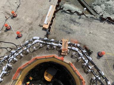 shaft in ground with safety areas signposted in orange