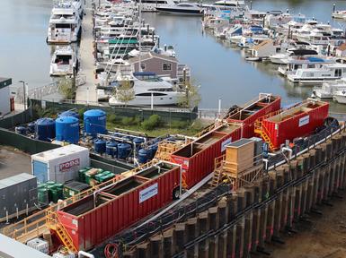 red tanks next to boats on riverside docks