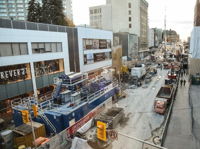 construction site in tight area down street with shops