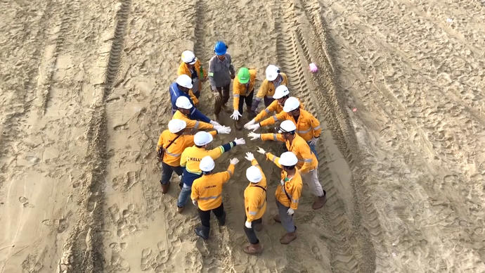 keller employees in a group putting their hands together on site